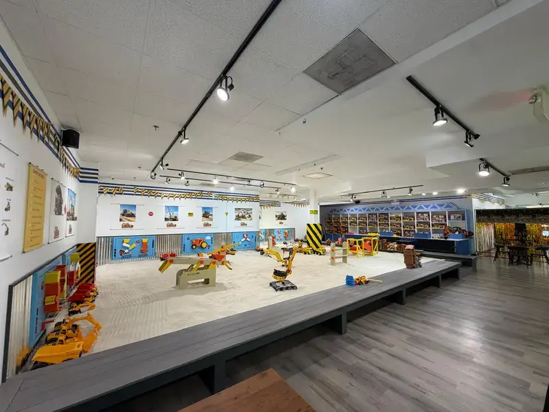 Wide view of the indoor sand arena with diggers and activity walls